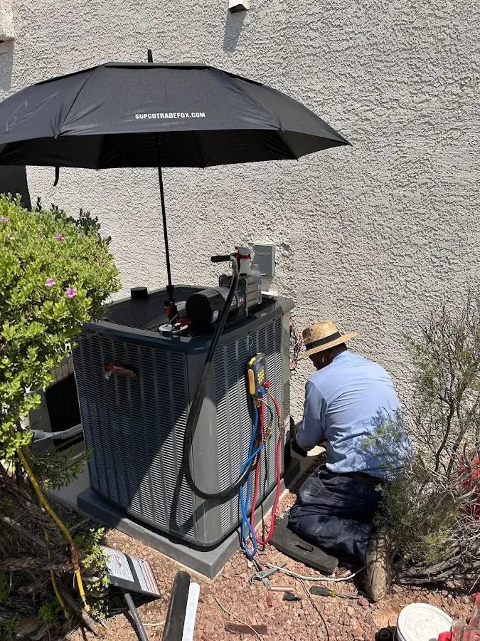 HVAC technician performing outdoor AC maintenance in East Greenwich